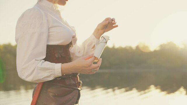 Real person Fantasy Woman captain one-eyed pirate hands holds opens paper scroll an old treasure map. Person looking for wealth. thief game old style. Nature sand island. Sexy girl steampunk costume
