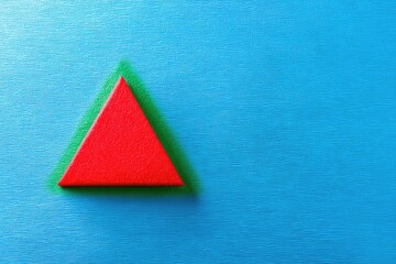 Red Triangle on Soft Green and Blue Textured Background