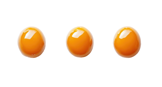 Three bright orange egg yolks arranged in a row, showcasing their glossy texture. Ideal for culinary presentations or recipes.