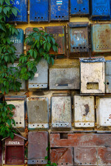 group of old mailboxes on the wall of a building, old weathered paint