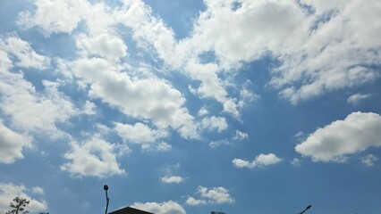 Soft Clouds in a Bright Blue Sky Over Urban Rooftops