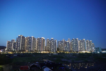 This photo shows a dense city skyline with high-rise buildings in the dark twilight.