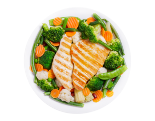 plate of grilled turkey and mix of steamed vegetables isolated on transparent background, top view