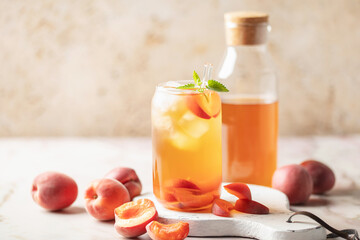 Apricot iced tea  in a glass on the table. Summer drink concept
