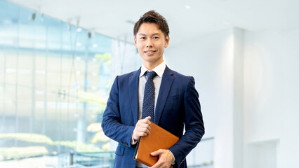 バインダーを持つ笑顔の男性ビジネスマン