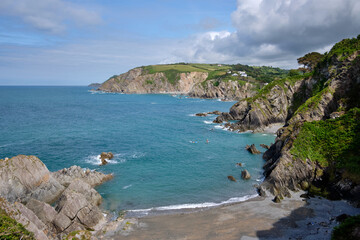Paddleboarders on the water in Lee Bay seen from the South West Coast Path, North Devon