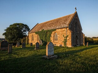 Obraz premium Old Stone Church and Country Graveyard in Warm Evening Light