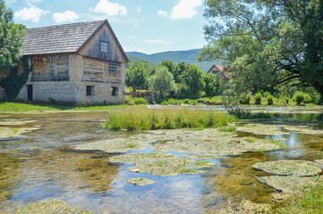 Obraz premium River Gacka springs, house on river bank