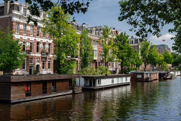 Houses on pontoons on the water on the canals of Amsterdam on a sunny day