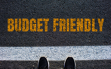 Budget friendly message written on asphalt road. Conceptual budget friendly symbol. Copy space.