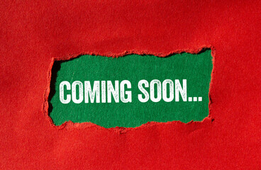 Coming soon message written on ripped torn red paper on green background. Conceptual coming soon symbol. Copy space.