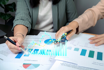 Business professional analyzing financial data with a holographic chart overlay showing stock market growth, investment success, and profit, representing technology and business intelligence concepts.