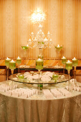 Elegant event table display with green decor and candles during a formal gathering in an indoor venue