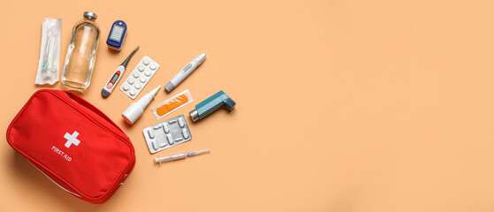 First aid kit and pills on beige background