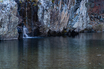waterfall and flowing stream in the autumn valley