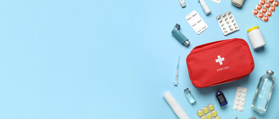 First aid kit and pills on blue background