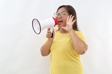 Asian woman screaming while holding megaphone with hands making announcement