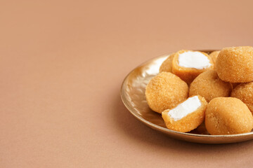 Plate with delicious fried mozzarella balls on beige background, closeup