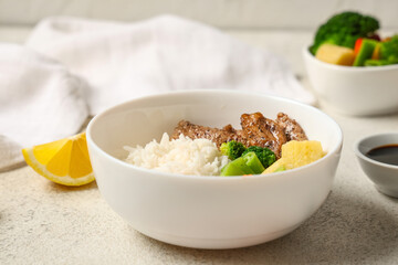 Bowl of tasty rice, chicken and vegetables on light table