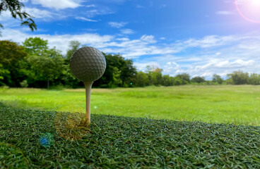 Golf clubs and ball on green grass at beautiful golf course with morning sunlight. Close up view of golf equipment on green grass.