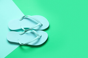 Beach flip-flops on color background