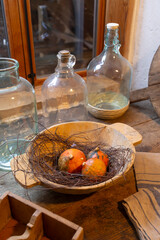 Small pumpkins resting in wooden bowl with empty glass jars on rustic table