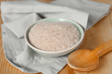 Bowl with psyllium husk powder with napkin on wooden background