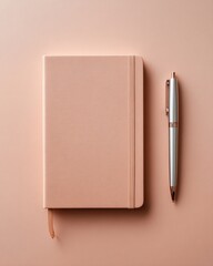Simple planning tools: A pale pink journal with elastic closure and a sleek metallic pen set against a matching pink background