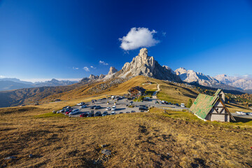 Passo Giau parking area with chapel and Nuvolau group dominating the landscape in Dolomites, Italy