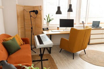 Interior of recording studio with workplace, sofa and synthesizer