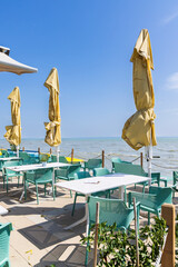 Outdoor restaurant tables and closed parasols overlooking Lake Balaton in Hungary