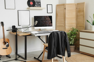 Interior of modern recording studio with workplace and musical instruments