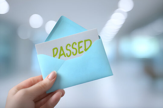 Hand holding envelope containing passed exam results