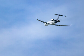 Passenger airplane flying in a clear blue sky over Hostivice, Czechia