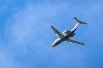 Private jet flying high in the blue sky over Hostivice, Czechia