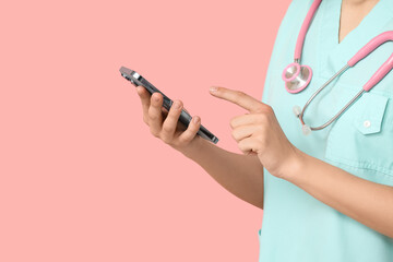 Female cardiologist with stethoscope and mobile phone on pink background, closeup