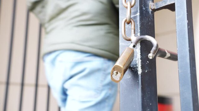 Lock hanging from open gate 4k
