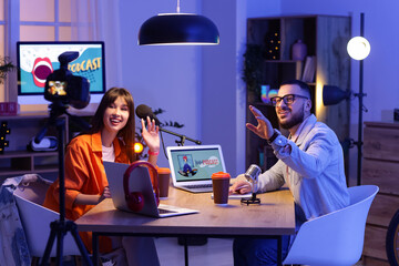 Young podcasters recording video at table in studio