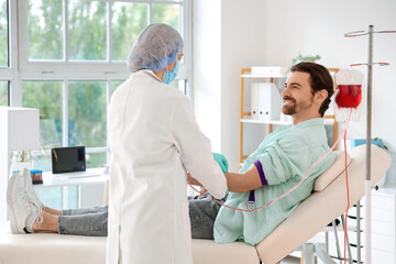 Female doctor taking blood from donor in clinic