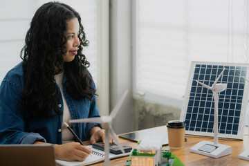 A female engineer uses a calculator for financial or technical calculations for a renewable energy...