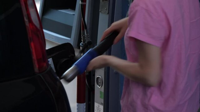 a woman refuels her methane car at self-service filling station