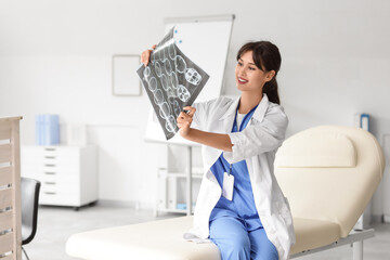 Female medical intern studying MRI scan in clinic