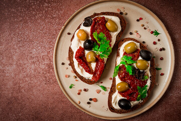 sandwich with cream cheese, dried tomatoes, olives, breakfast, top view,