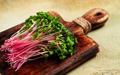 fresh micro-greens, beetroot sprouts, on a wooden chopping board, top view, no people,