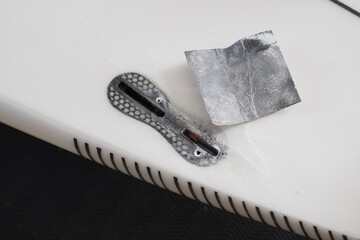 Surfboard repair process showing a fixing a fin box with a sanding tool.