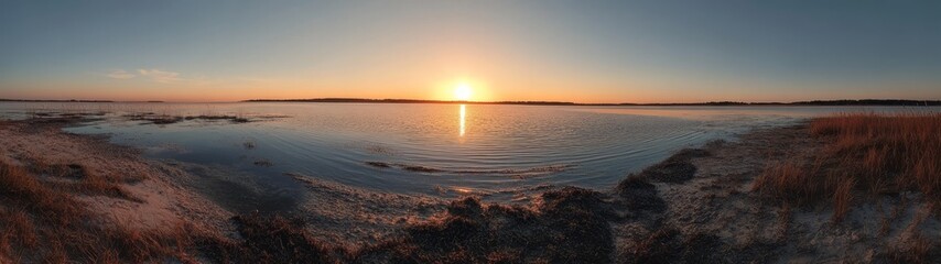 Obraz premium Breathtaking Sunset Over Calm Waters With Reflections and Silhouetted Grass at a Serene Lakeshore in the Early Evening