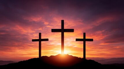 Three crosses on hilltop silhouetted against dramatic sunset sky