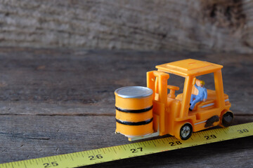 Toy model construction workers on a yellow tape measuring.