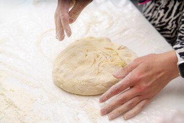 Making fresh dough for baking at a kitchen table during a culinary class in the morning