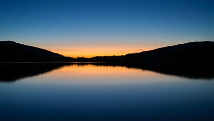 Fototapeta premium Serene tranquil landscape depicting a stunning sunset over a calm lake reflecting the colorful sky and mountain silhouettes
